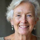 Porträt einer älteren Frau mit einem gütigen, weisen Lächeln.